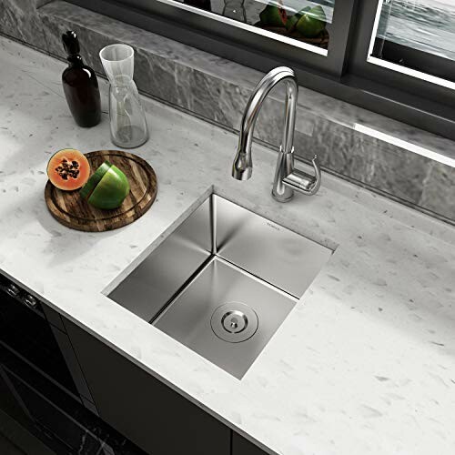 Modern kitchen sink with marble countertop and fruits.