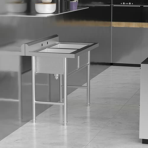 Stainless steel kitchen sink with modern design and metal legs.